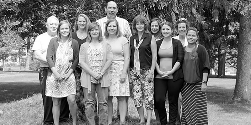 Eleven WRC staff members stand together while smiling.